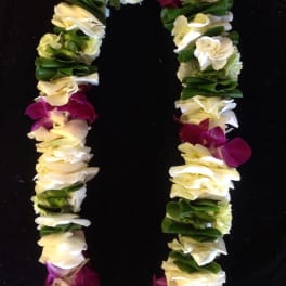Flower lei with white, yellow, and purple blooms on a black background