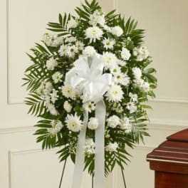 White floral standing spray with a ribbon on an easel