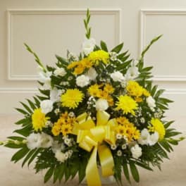 Yellow and white floral arrangement with a yellow ribbon