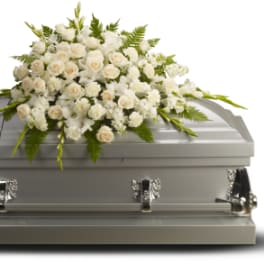 White floral spray on a gray casket