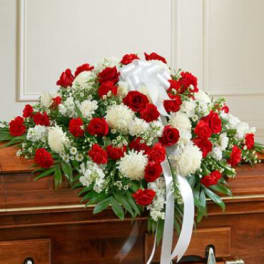 Red and white funeral spray with ribbon on a casket
