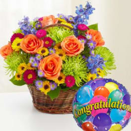 Basket of colorful flowers with a congratulatory balloon