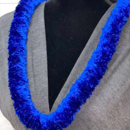 Bright blue fluffy lei necklace displayed on a dress form