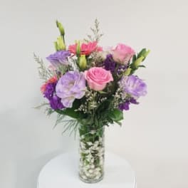Pink, purple, and white bouquet in a clear glass vase