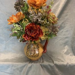 Orange floral arrangement in a decorative ceramic vase