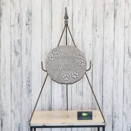 Memorial plaque on a metal stand with paw prints