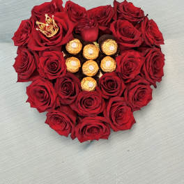 Heart-shaped red rose arrangement with gold-wrapped chocolates in the center