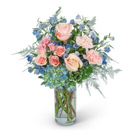 Pink roses and blue flowers in a clear glass vase