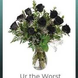 Bouquet of black roses in a clear glass vase with text below