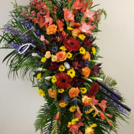 Tall standing floral spray with orange, red, yellow, and purple flowers