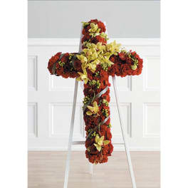 Cross-shaped floral tribute with red and yellow flowers on a stand