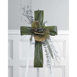 Green floral cross with trailing foliage and ribbon accents