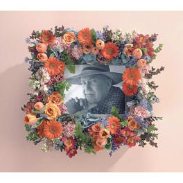 Floral photo frame with orange and pink flowers around a black-and-white portrait