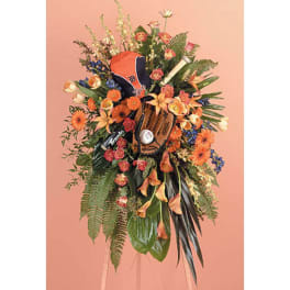 Large floral standing spray with a baseball glove and cap centerpiece