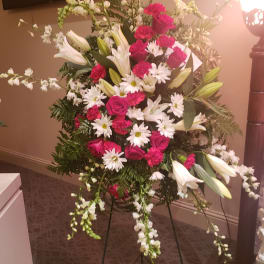 Standing floral spray with pink roses, white lilies, and daisies