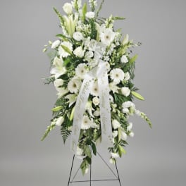 White sympathy standing spray on an easel with ribbon