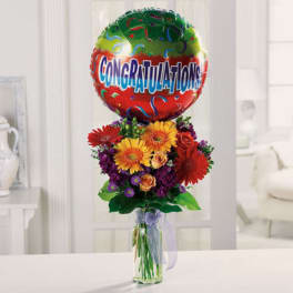 Bouquet of mixed flowers with a congratulations balloon in a glass vase