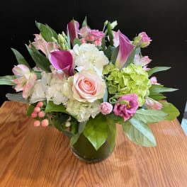 Pink and white mixed flower arrangement in a glass vase