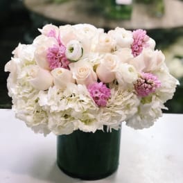 White and pale pink flowers arranged in a dark green vase