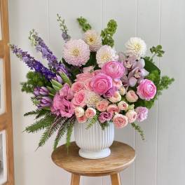 Pink and purple mixed flower arrangement in a white vase