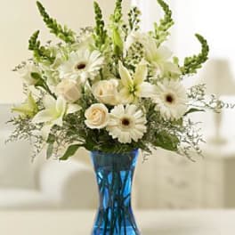 White flowers arranged in a blue glass vase
