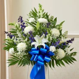 White and purple floral standing spray with a blue ribbon