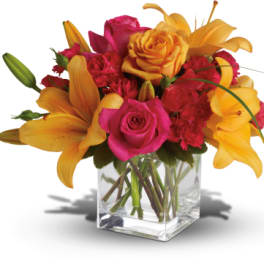 Bouquet of pink roses and yellow lilies in a clear glass vase