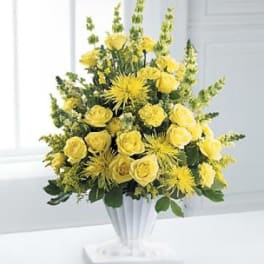 Yellow roses and spider mums arranged in a silver vase
