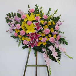Standing floral spray with pink, yellow, and white blooms on an easel