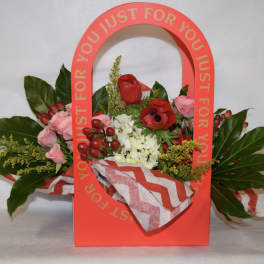 Red floral gift bag with pink and red flowers and a chevron tissue wrap