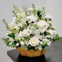 White roses and mixed white flowers in a woven basket