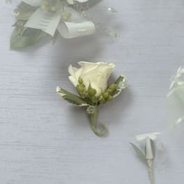 White rose boutonniere with green accents