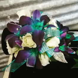 Bouquet of white roses with purple and teal orchid-like flowers and ribbon