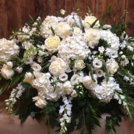 Large white floral arrangement with roses and hydrangeas