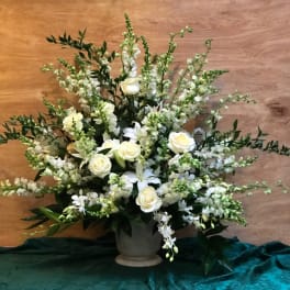 White roses and lilies arranged in a gray vase