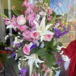 Tall mixed bouquet with pink roses, white lilies, and purple flowers