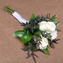 White rose bouquet with dark greenery and a white ribbon wrap