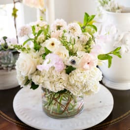 White and blush floral arrangement in a clear glass vase