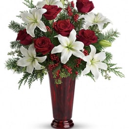Red roses and white lilies arranged in a tall red vase