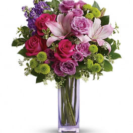 Pink and purple mixed bouquet in a tall glass vase