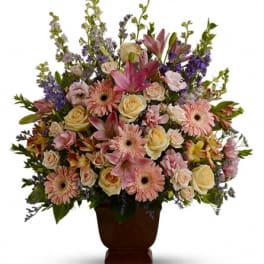 Mixed pink and cream flowers in a brown vase