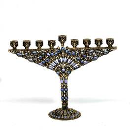 Ornate blue and gold jeweled menorah on a white background