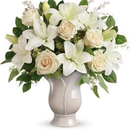 White lilies and cream roses in a beige vase