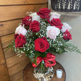 Bouquet of red and white roses in a glass vase with a red ribbon
