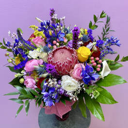 Colorful mixed bouquet with a large pink protea in a vase