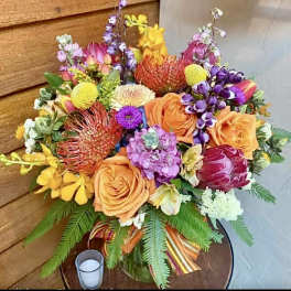 Colorful mixed bouquet with roses, protea, and orchids