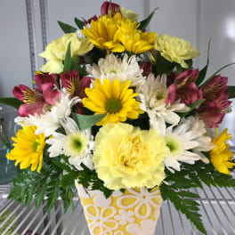 Yellow and white mixed flower arrangement in a patterned ceramic vase