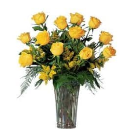 Yellow roses arranged in a tall glass vase