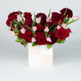Red roses and pink tulips in a white box