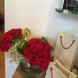 Two red rose bouquets in a glass vase with baby's breath
